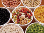 Beans assorted by color in different containers, all mixed together in the center one