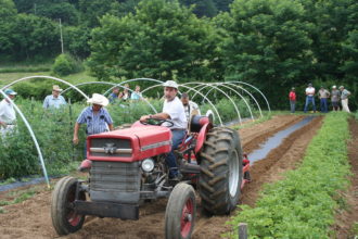 ASD director Anthony Flaccavento drives a tractor during a farm tour