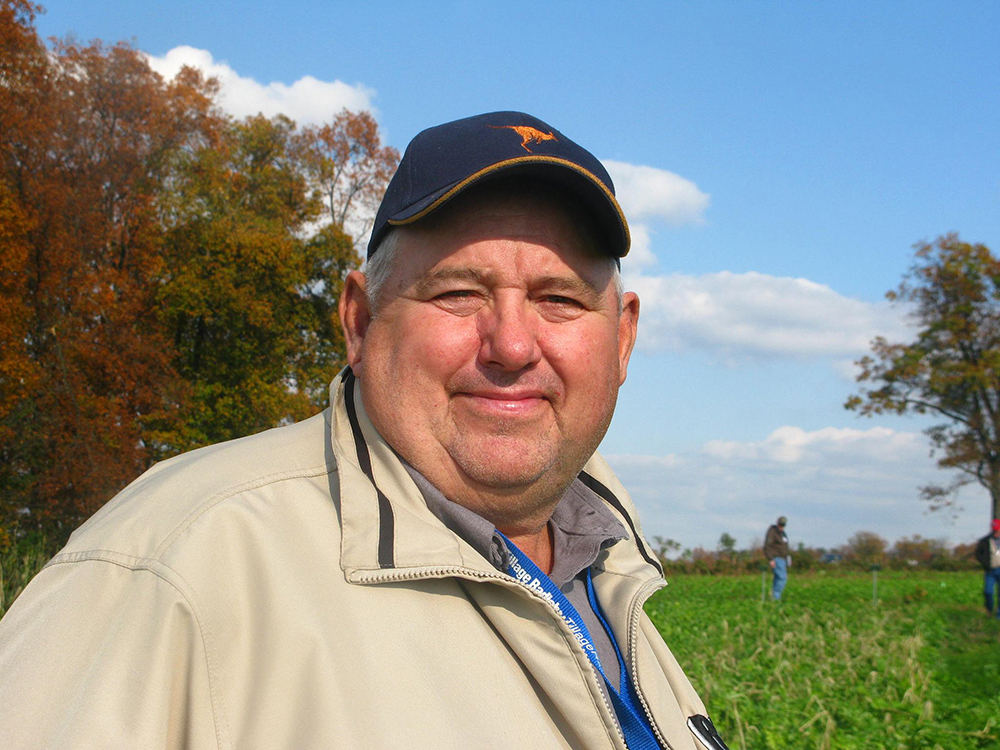 man (Dave Brandt) standing in a field wearing a hat