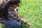 woman crouching down to examine the grass