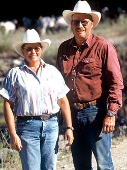 husband and wife standing on their goat farm in Idaho