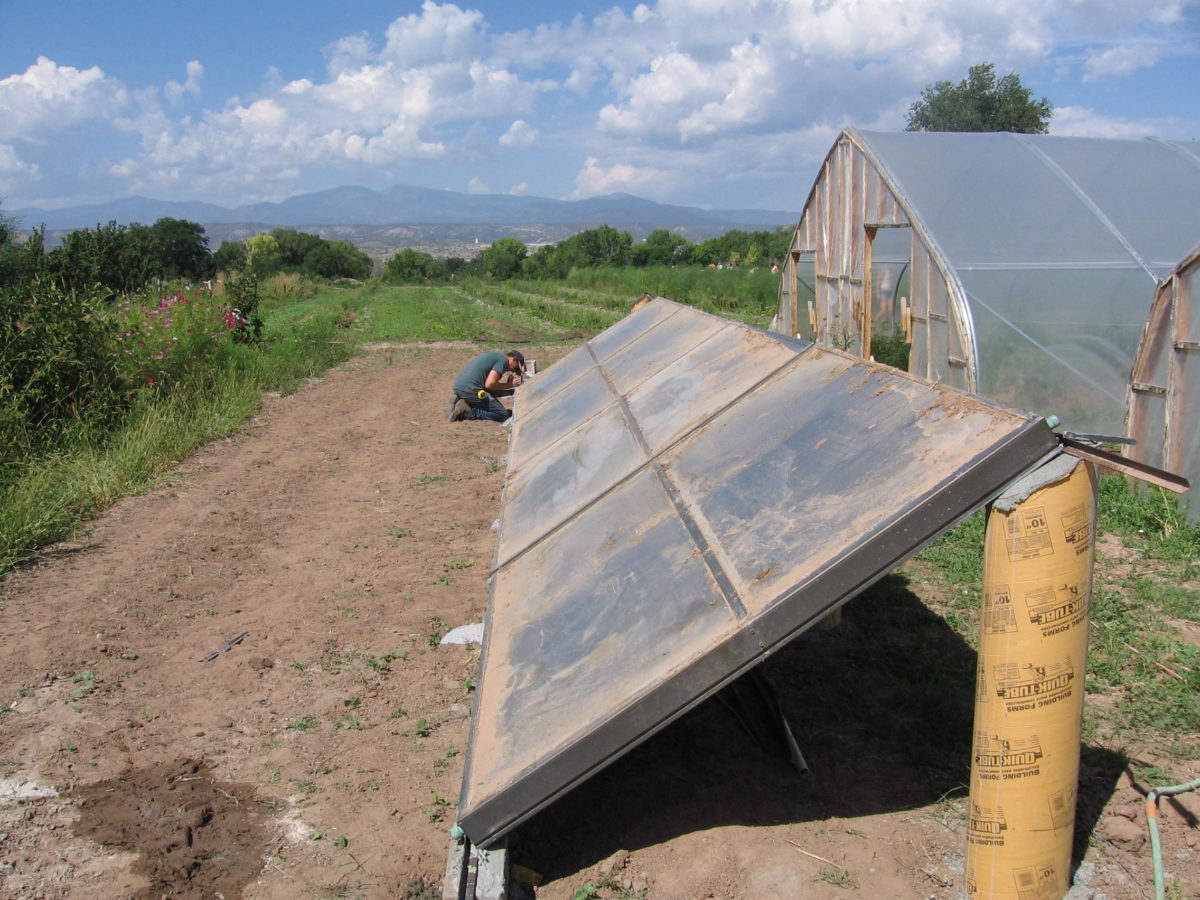 Solar panels in front of a greenhouse