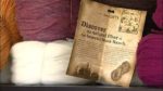 A vintage piece of paper against spools of yarn
