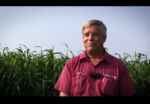 Donn Branton standing in front of his field smiling