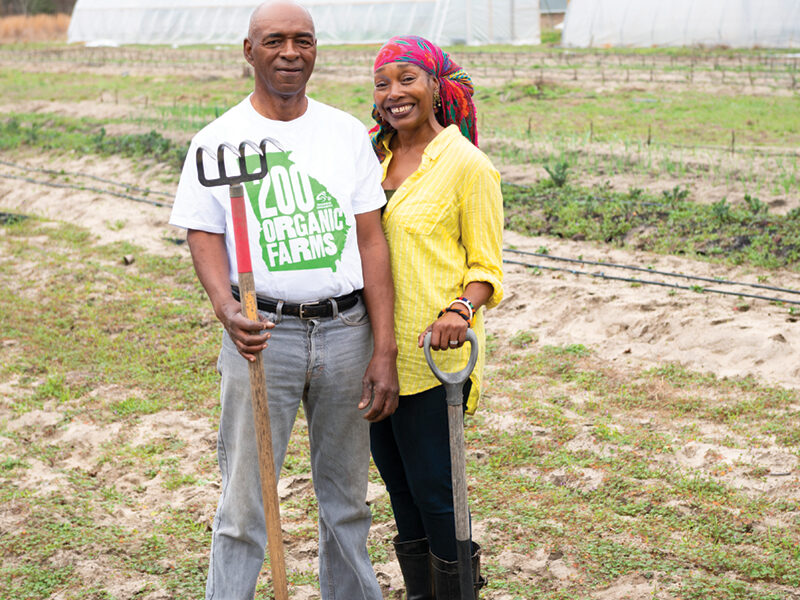 Husband and wife posing at their farm.