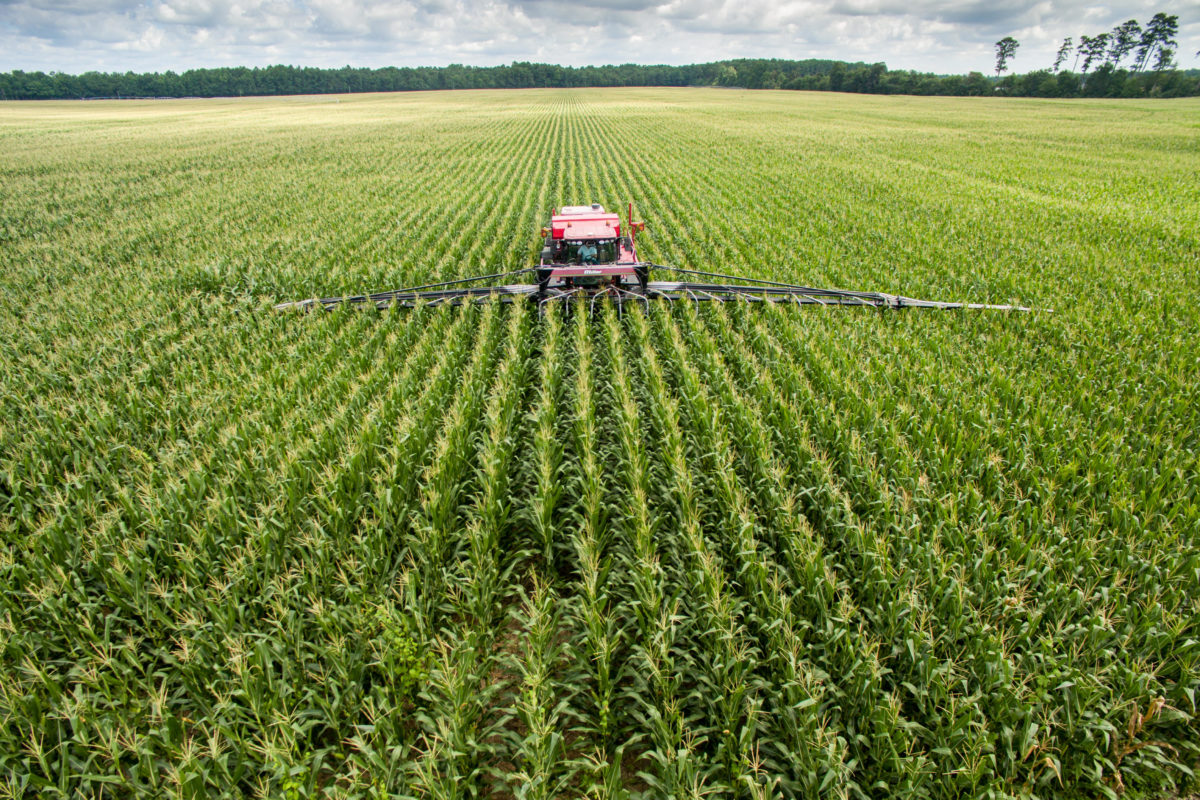 Interseeding through a wide attachment on a tractor