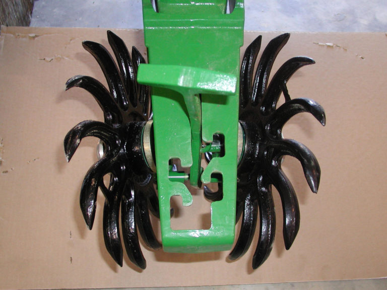 A green tractor with black wheels with spokes coming out of it