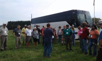 Delvin Farms People standing around in front of a bus at Delvin Farms