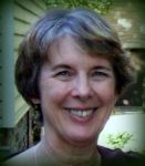 A headshot of a woman with short gray hair outside next to a building