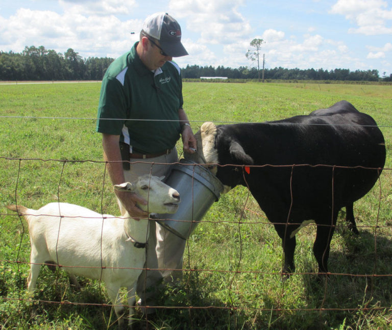 Lynn Barber Lynn Barber holding buckets for a cow and a goat to feed out of