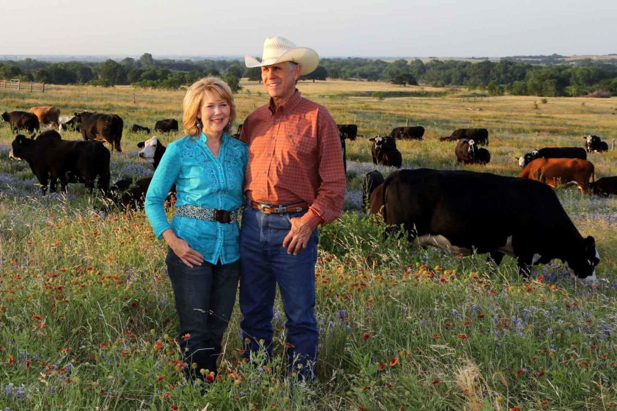 Ranching couple posing in front of cattle Ranching couple posing in front of cattle