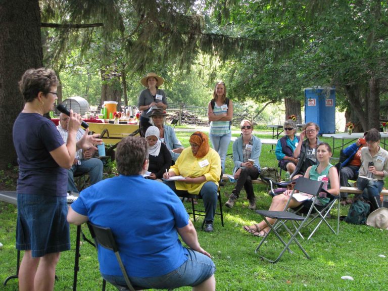 A woman speaking to women outdoors