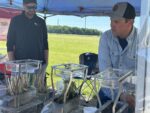 two men demonstrating water infiltration in soil and roots