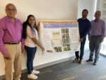 Southern SARE Young Scholar stands next to her research poster.