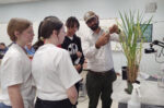 Researcher showing young students research in the lab.