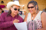 Two people looking at a piece of paper together and talking