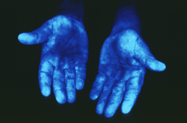 pair of hands glowing blue under special light