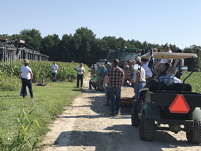 farmers in field listening to a presentation