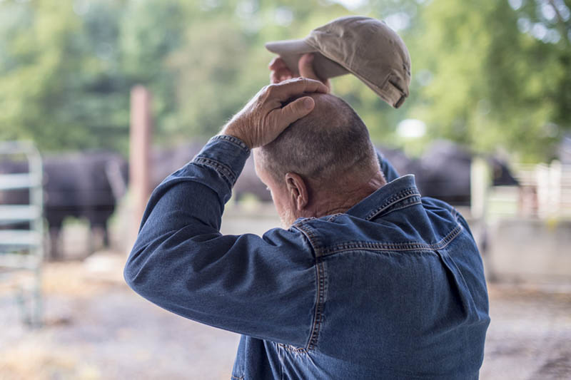 A person is rubbing his head, giving the appearance of being worried