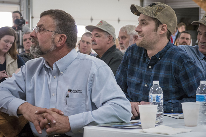 A crowd of farmers listening to a presentation