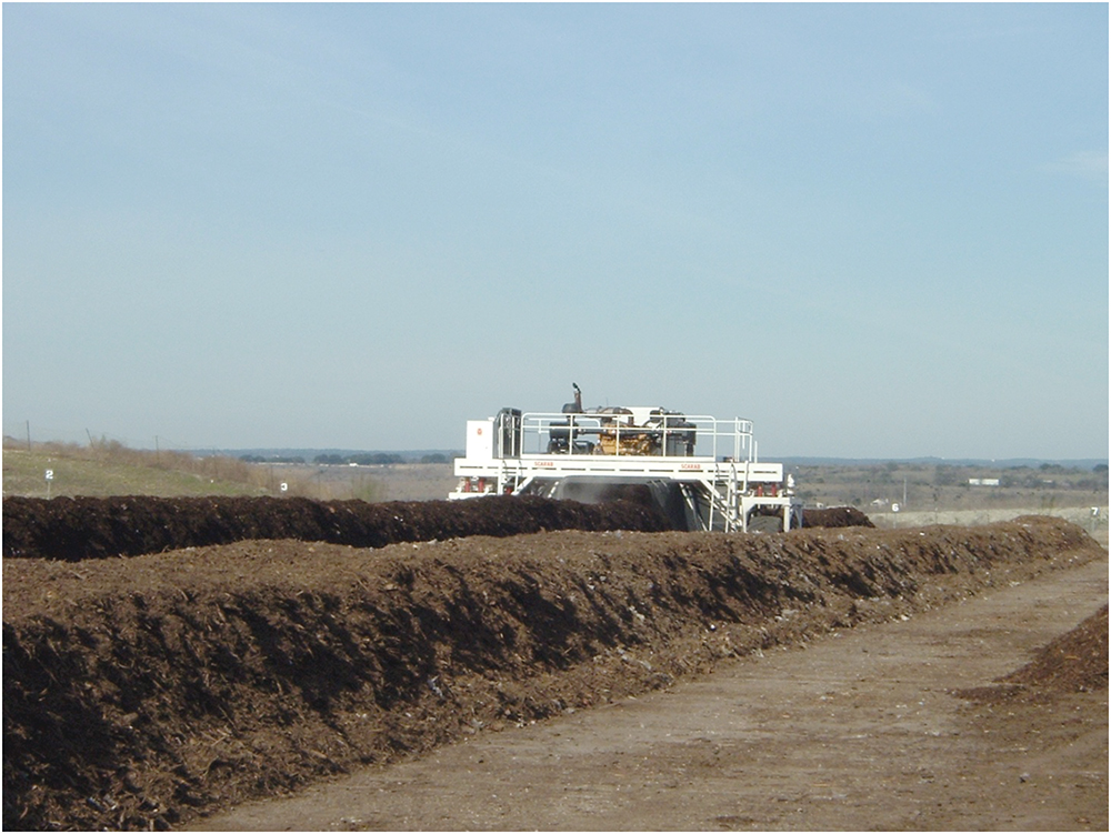 compost windrow with a white structor in a hazy field