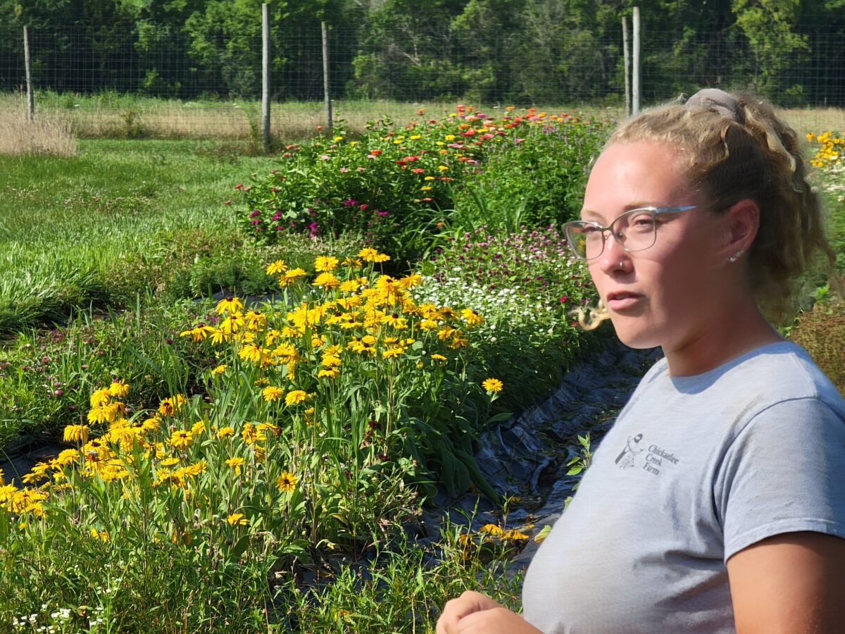 A woman standing in front of flowers in a field