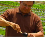 grandebackpacksprayer.jpg Man using an agricultural took in front of his field