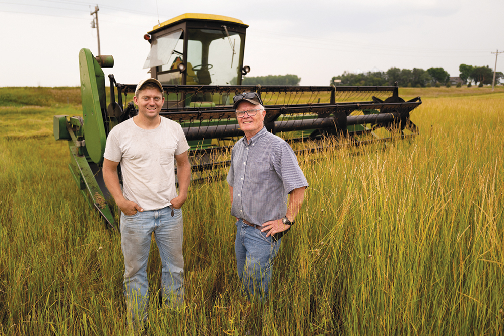 Two farmers posing in a grain field.