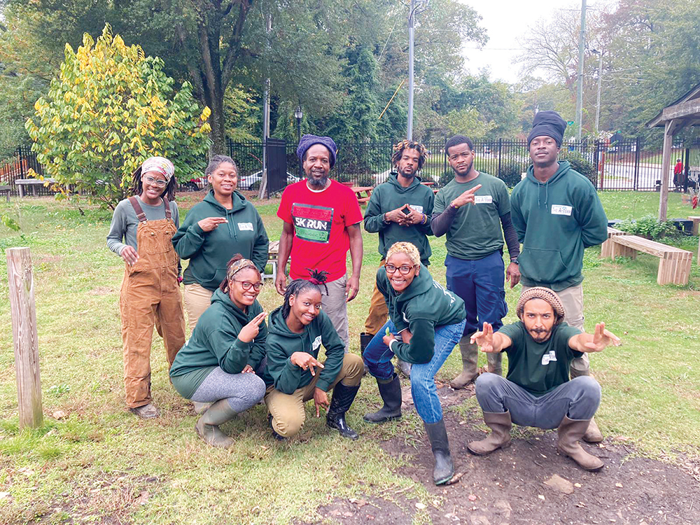 A group of farmers all collected together outside posing for a picture