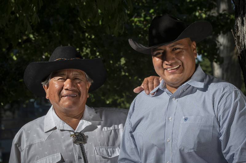 An older Native American rancher posing with his adult son