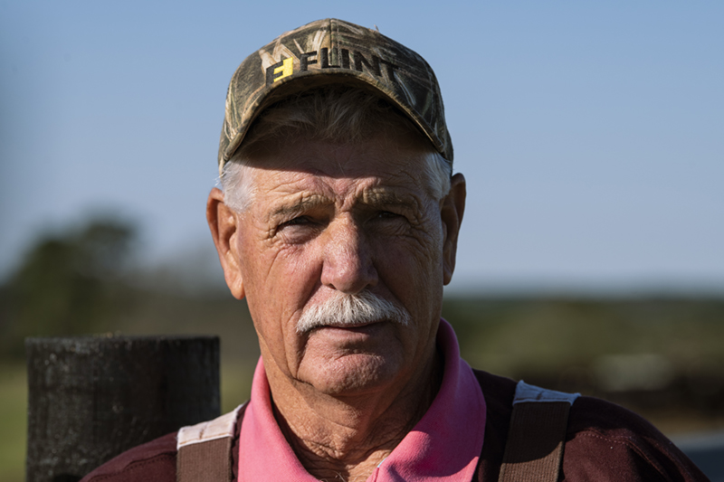 Older white male farmer wearing ball cap