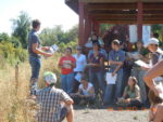 Man on a pedestal teaching a group of people outside