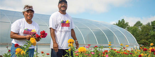 people people holding flowers in front of a greenhouse