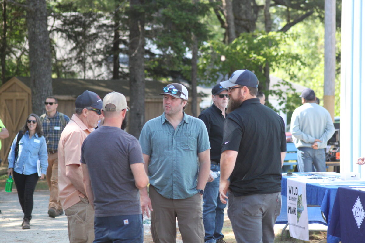 Men standing in a circle talking outside 