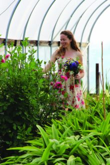 Violet Stone picking flowers in a greenhouse