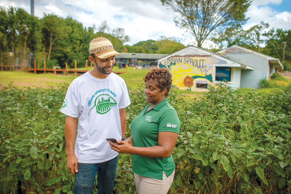 An NRCS employee talking with a farmer at his urban farm.