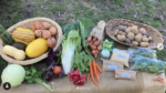 A table outside filled with various fresh fruits and vegetables in baskets