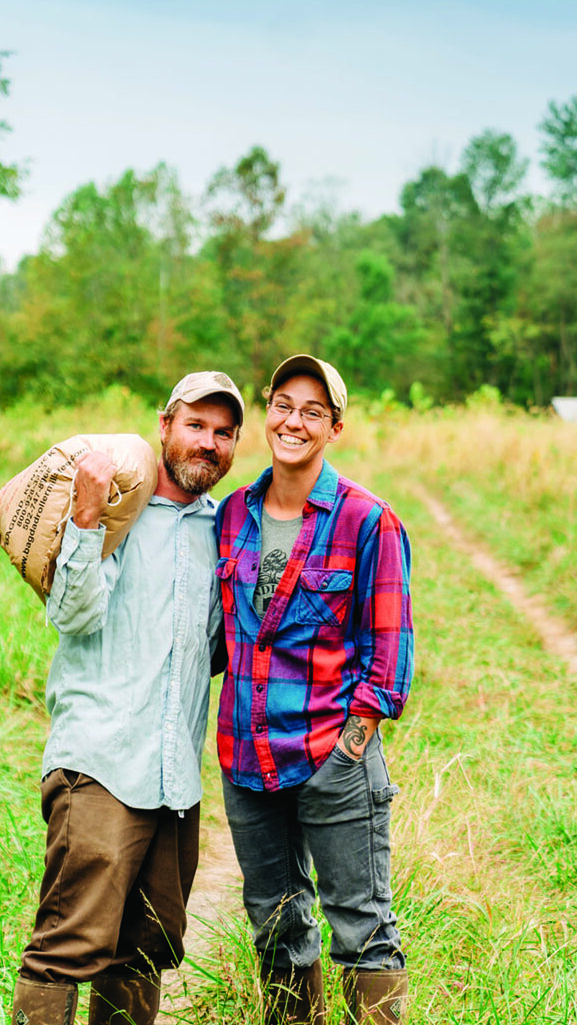 A young couple pose in their farm field